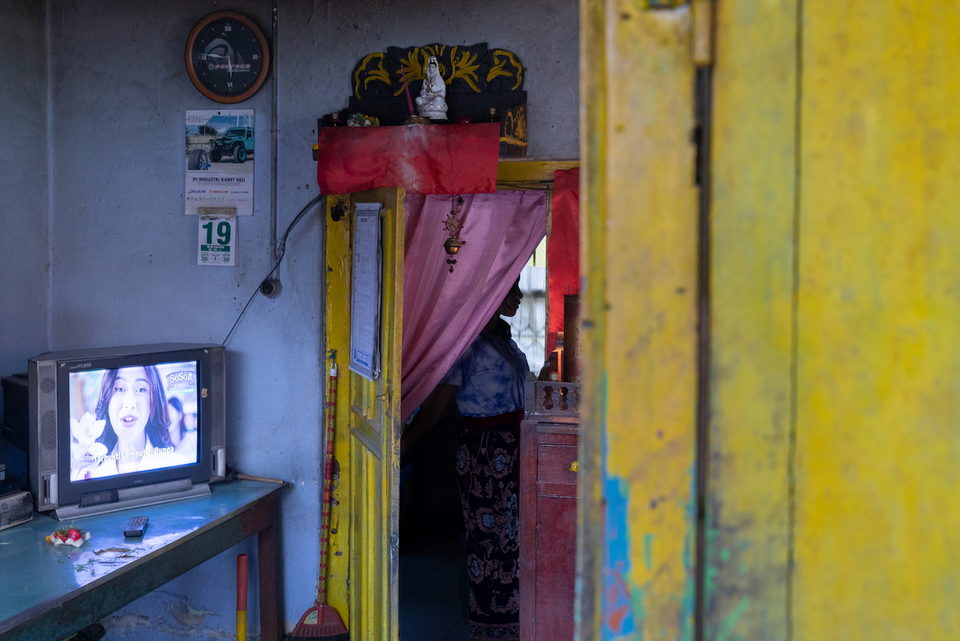 A doorway hung with a pink curtain, a small television in the room beyond.