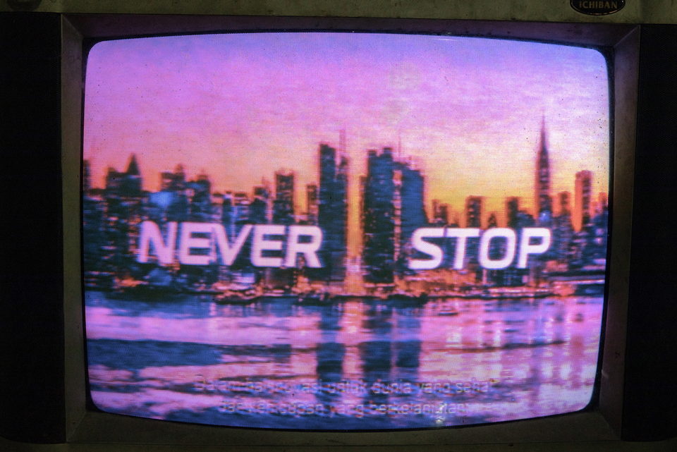 A television showing a city skyline with the words NEVER STOP.